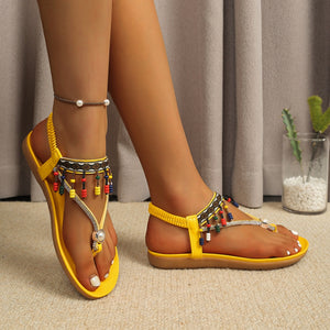 Yellow bohemian ankle strap sandals with colorful beads and a pearl detail.