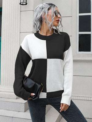 Colorblock knit sweater with black and white checkerboard pattern, crew neck, and long sleeves.