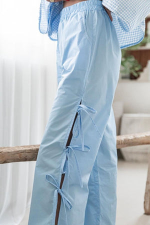 Light blue palazzo trousers with side tie details and a relaxed fit.