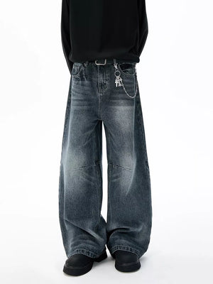 Belted wide-leg jeans in dark wash cotton with unique paneled design and chain detail.