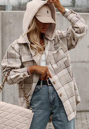Oversized plaid shacket with attached hoodie and button front, styled with jeans and a baseball cap.