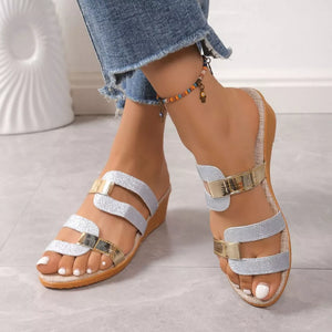Glistening dual-strap wedge sandals in silver and gold glitter with a comfortable cork sole.