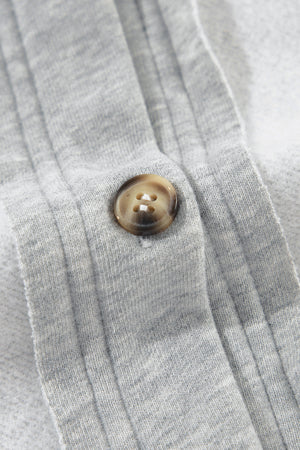 Light gray cotton utility vest with a button closure and contrast trim detail.