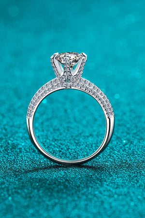 Silver pavé halo moissanite solitaire ring with a round cut center stone.
