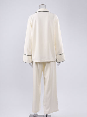 Cream button-up pajama set with black piping on collar, cuffs, and hem.