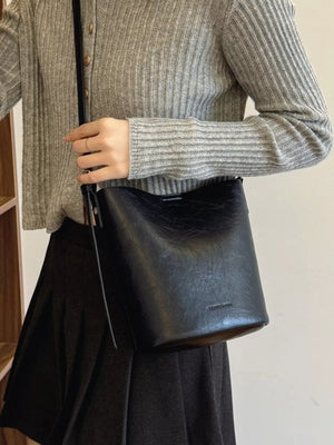 Black distressed vintage bucket crossbody bag with adjustable strap