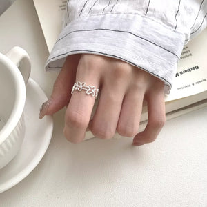 Sterling silver open ring with delicate floral motif pattern.