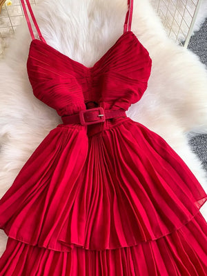 Red belted pleated midi dress with spaghetti straps and a buckle.