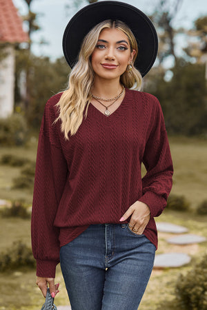 Burgundy cable knit v-neck pullover sweater with textured detail.