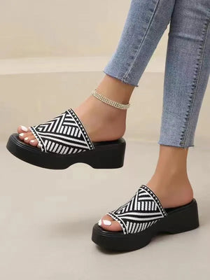 Platform knit slide sandals in black and white geometric stripe pattern with a thick sole.