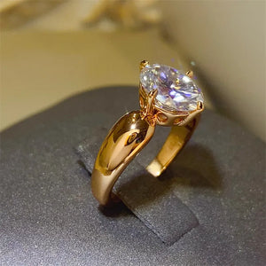 Gold sculpted oval moissanite solitaire ring with a bright, clear stone.