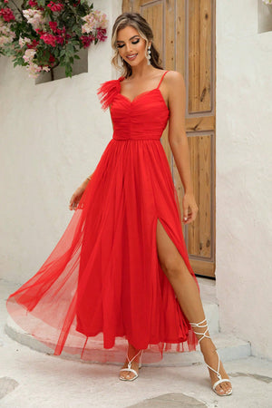 Red tulle gown with asymmetrical ruffle detail, sweetheart neckline, spaghetti straps, and high slit.