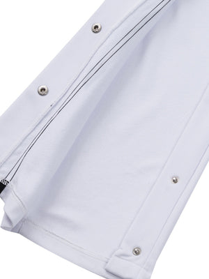 White men's track pants with snap buttons and black contrast stitching detail.