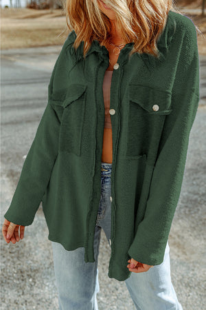 Green button-up coat with two chest pockets and textured fabric.