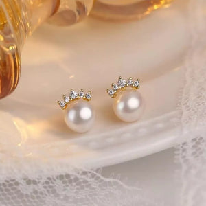 Lustrous pearl and zircon stud earrings with a crown design.