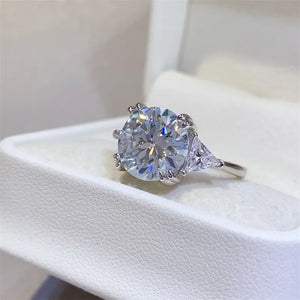 Sterling silver ring with a large round moissanite and trillion-cut side stones.
