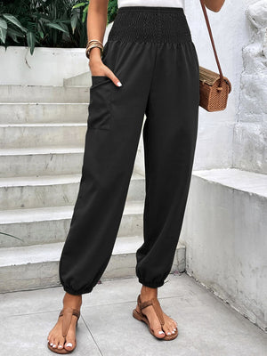 Black relaxed-fit cargo pants with smocked waist and cuffed ankles.