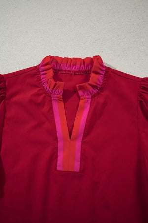Red maternity blouse with ruffled neckline and striped V-neck detail.