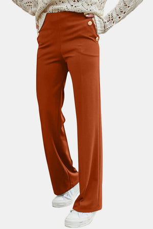 Button detail wide leg trousers in caramel, styled with a cream sweater and sneakers.
