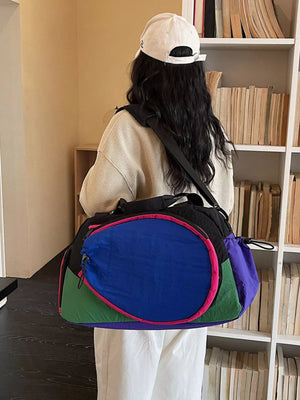 Vibrant nylon sport duffle bag with adjustable strap, color block design in royal blue, green, purple, and pink accents.
