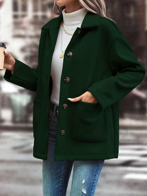 Oversized dark green shirt jacket with flap pockets and button front.
