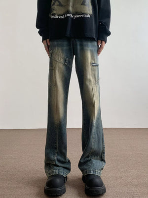 Men's vintage wash blue flare jeans with distressed details and zip pockets.