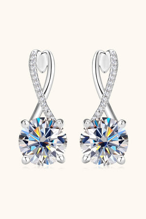 Silver crossover moissanite huggie earrings with pavé diamond accents.
