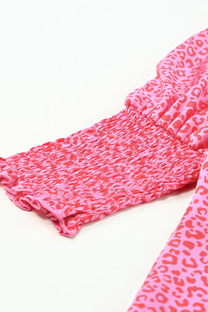 Pink leopard print blouse with smocked cuffs and sleeves.