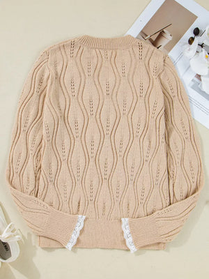 Beige acrylic V-neck knit sweater with wavy openwork pattern and white lace trim at cuffs.