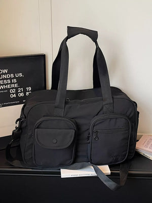 Black nylon duffle bag with multiple front pockets and adjustable strap.