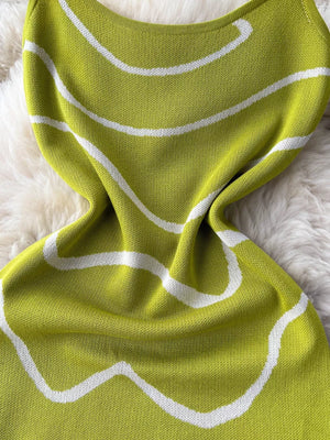Green wavy knit midi dress with spaghetti straps and white abstract pattern.
