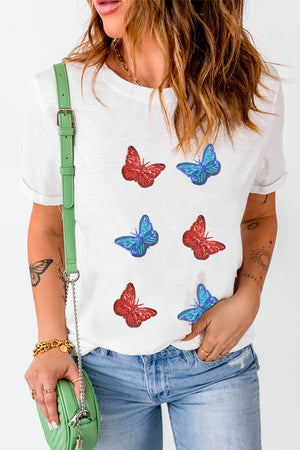 White t-shirt with embroidered red and blue butterfly motifs.