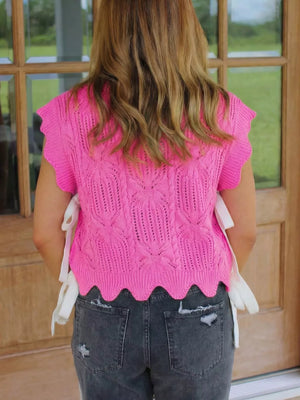 Chic openwork knit sweater vest in pink with cable knit pattern and scalloped hem.