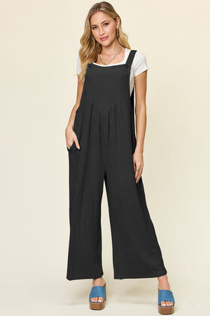 Ribbed black wide-leg pinafore jumpsuit with square neckline and pockets