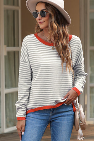 Striped crewneck sweater with contrast orange trim and long sleeves.