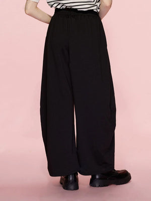 Black pleated drape palazzo trousers with wide legs and an elastic waistband.