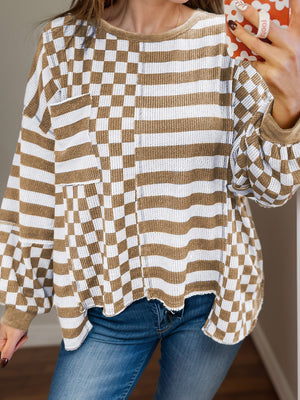 Asymmetrical checkered patchwork knit top in camel and white with crew neck and long sleeves.