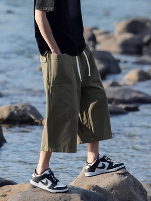 Relaxed fit cropped sweatpants in green with drawstring and pockets.