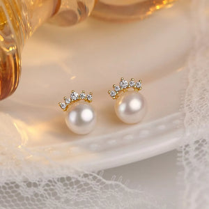 Lustrous pearl and zircon stud earrings with a crown design.