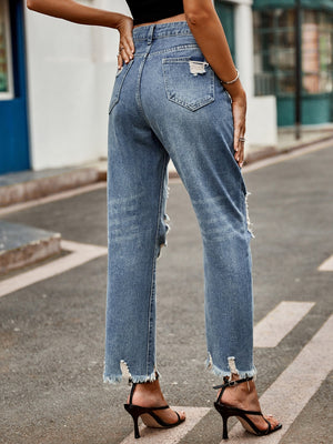Medium wash denim jeans with ripped knees and raw hem straight leg cut.