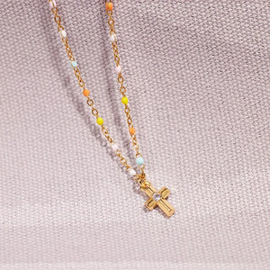 Gold bead necklace with rainbow beads and a crystal cross pendant.