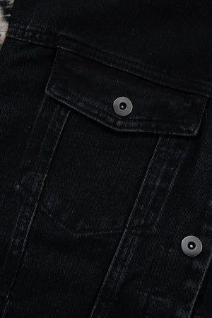 Black denim trucker jacket with snap button chest pockets and metal hardware.