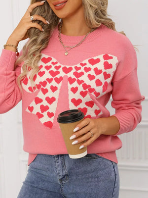 Pink acrylic knit sweater with a large white bow pattern filled with red hearts, round neck.