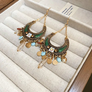 Bohemian dark green crescent drop earrings with gold alloy details and charms.