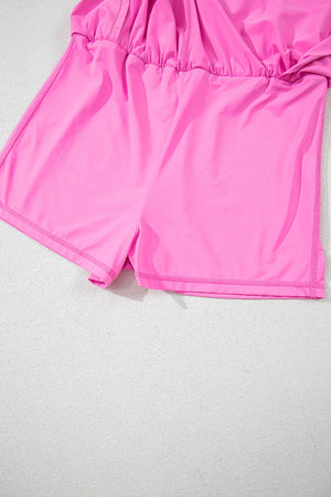 Fuchsia pink active romper with scoop neck and ruched waist detail.