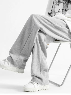 Light gray casual loose fit sweatpants with a wide leg, styled with white sneakers.