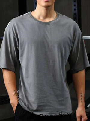 Distressed oversized gray t-shirt with raw edges and crew neck.