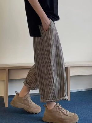 Men's wide-leg sweatpants with vertical pinstripe pattern and rolled cuffs.