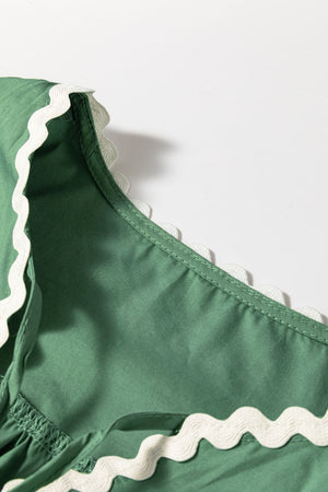 Moss green blouse with white scalloped trim detail on neckline and puff sleeves.