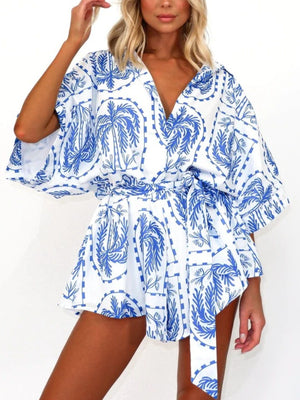Blue celestial print wrap romper with short sleeves and tie waist